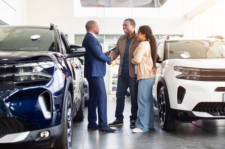 Happy customers and car dealer celebrating successful deal